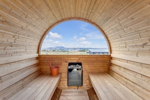 Relax and unwind in style: a cozy sauna and hot tub overlooking a breathtaking sunset.