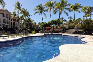 Take a dip in the resort pool framed by palm trees, lounging space, and beautiful Hawaiian greenery.

