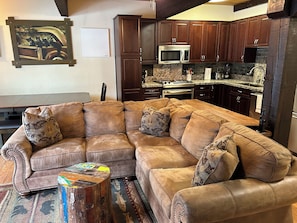 Fully equipped kitchen with large refrigerator, stove, dishwasher, & microwave.