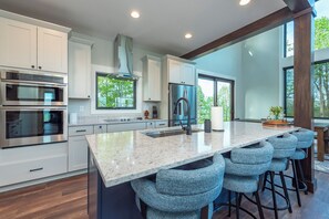Kitchen with island seating for 4, wet bar, and coffee station with a drip-style coffee maker and Keurig