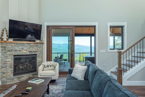 Living room with cozy seating, 55" Smart TV for streaming, and gas log fireplace