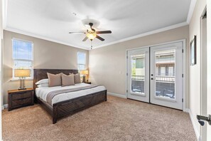 Rest easy in this spacious, sunlit bedroom with direct patio access and a luxurious bed.