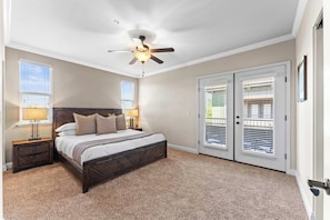 Rest easy in this spacious, sunlit bedroom with direct patio access and a luxurious bed.