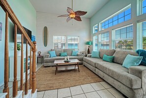 Bright and airy living room with two comfy sofas and a TV.