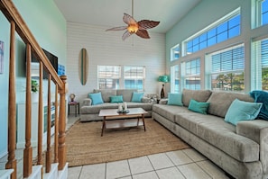 Bright and airy living room with two comfy sofas and a TV.