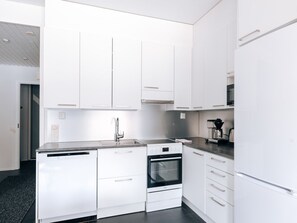 The apartment's kitchen is well-equipped and includes an oven, full-size fridge-freezer, stove, and dishwasher.