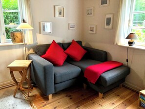 Ein kleines 2er Sofa im Wohnzimmer mit Kamin und TV