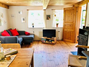 Ein kleines 2er Sofa im Wohnzimmer mit Kamin und TV