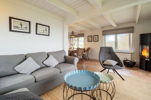 Gemütliches Wohnzimmer mit Ofen und Meerblick