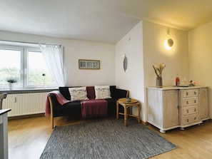 Wohnzimmer mit Küchenzeile, TV und Essbereich