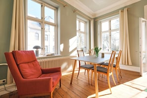 Wohnzimmer mit Couch, Esstisch und TV