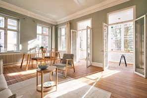 Wohnzimmer mit Couch, Esstisch und TV