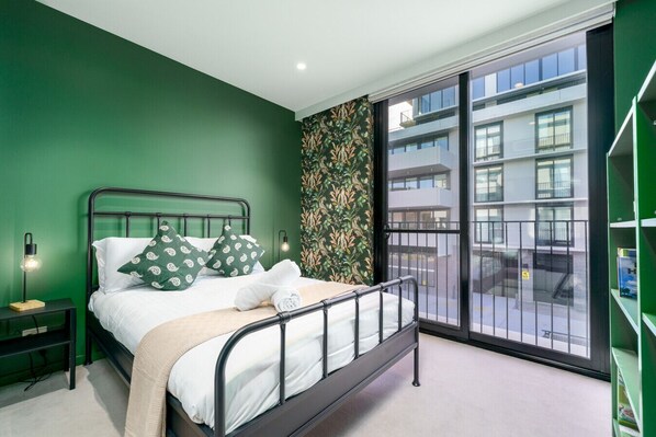 This light-filled bedroom blends deep greens and tribal patterns for a restful space with cultural flair.