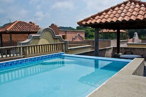 Roof top pool with grill and palapa.