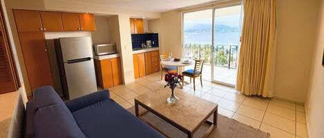Sala con sofá cama, comedor y cocina con refrigerador y microondas. Hermosa vista al mar.