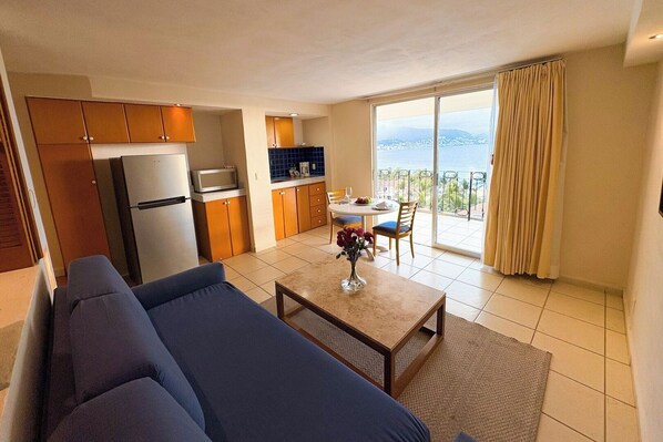 Sala con sofá cama, comedor y cocina con refrigerador y microondas. Hermosa vista al mar.
