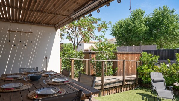 Terrace opening onto the garden with barbecue and garden furniture
