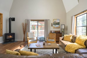 Spacious living room with vaulted ceiling, plenty of natural light, and cozy fireplace