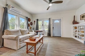 Bright and inviting living area with a comfortable sofa, natural light, and a charming design.