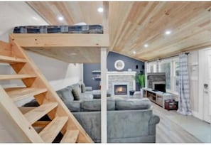 Love in the loft: elevated sleeping quarters, open space, and a fireplace that warms more than just the room.