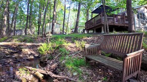 Gaze out at the babbling brook as sunlight dances through the trees—your private deck features a bar, hot tub, TV, and cozy seating, creating the perfect scene for morning coffee or moonlit drinks with someone special.