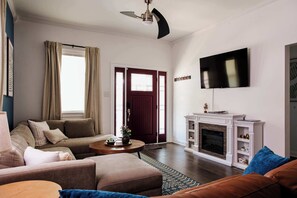 Plenty of room for your whole group in this airy living room — sink into the cozy sectional and extra couch, and unwind with the Smart TV and warm glow of the electric fireplace.