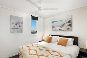 The serene bedroom is set with a king-size bed with a ceiling fan to keep things comfortable.