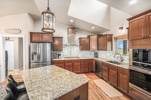 A modern kitchen with stainless steel appliances and a sleek granite countertop, perfect for preparing your favorite meals, just like at home.