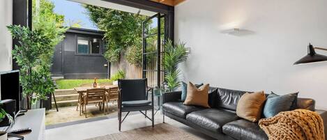 Relax in the contemporary living area, which opens effortlessly onto a leafy courtyard with outdoor dining – ideal for enjoying your morning coffee or an alfresco supper beneath the stars.