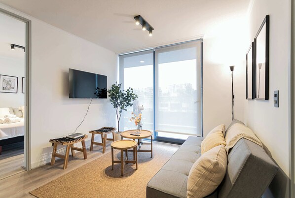 Relax in this modern living room with natural light, cozy seating, and a sleek design—perfect for unwinding after a day of exploring.