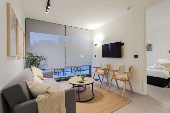 Relax in this cozy living room with stylish decor, a comfy sofa, and a smart TV, perfect for unwinding after a day of exploring.