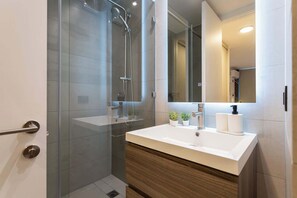 Experience modern comfort in this sleek bathroom featuring a spacious shower and elegant finishes for a refreshing stay.