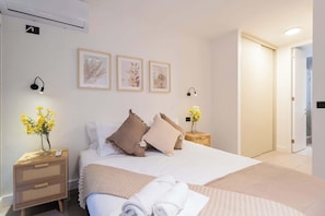 Experience comfort in this beautifully styled bedroom, featuring soft lighting, cozy decor, and a touch of nature with fresh flowers.