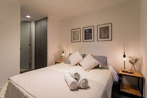 Relax in this cozy bedroom with soft lighting and elegant decor, perfect for a restful night's sleep.
