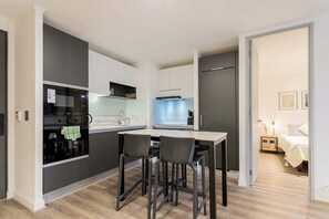 Modern kitchen with sleek design and cozy dining area, perfect for enjoying a home-cooked meal.