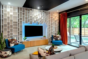 Spacious Living Room With Smart TV, Beautiful Decor, And Direct Pool Access