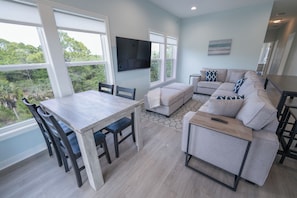 Living room w/ large sofa and multiple dining options