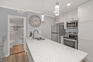 Recently refurbished kitchen with full-size stainless steel fridge.