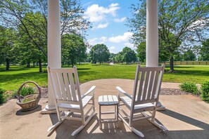 Covered front porch with rocking chairs and river views