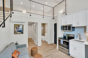 Relax in the inviting living room, complete with cozy seating and a flat-screen TV, offering a comfortable space to unwind during your stay