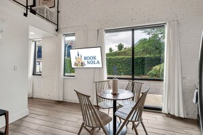 Charm meets natural radiance as the living room’s expansive windows invite the essence of New Orleans right inside