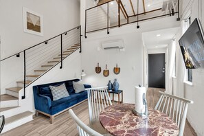 Stylish open-concept loft with modern decor, cozy seating, and vibrant New Orleans charm.