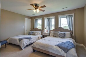 Unwind in the upstairs second bedroom, featuring two cozy queen beds for a comfortable night’s stay.
