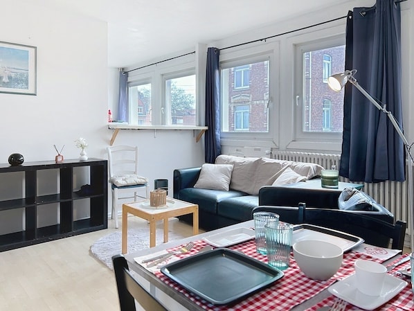Séjour spacieux avec canapé en cuir, table à manger et fauteuil confortable.