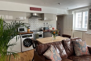 A fully equipped kitchen open-planned to the living room.