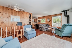 Cozy, rustic living space featuring wood accents, comfy seating, and a charming cottage vibe — perfect for lakeside family getaways.