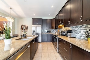 Featuring sleek stainless steel appliances, ample storage with easy-to-reach cabinets, and a spacious layout perfect for preparing meals together. It offers all the space and tools you need to make mealtime a fun and effortless part of your day!