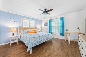 A spacious master bedroom with plenty of closet space and calming coastal decor.