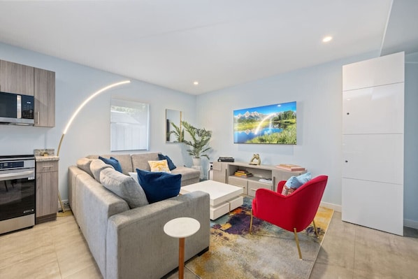 Bright, modern living space with cozy seating and vibrant touches