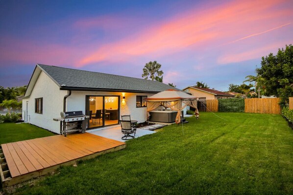 Backyard retreat with private hot tub and BBQ grill.